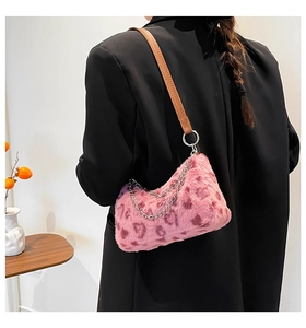 Détail du sac en fausse fourrure léopard rose avec chaîne sur mannequin en blazer noir