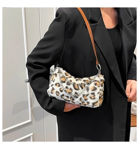 Gros plan d'un sac bandoulière en fausse fourrure léopard avec chaînes sur un blazer