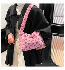 Detail of pink leopard print faux fur shoulder bag texture on black coat background