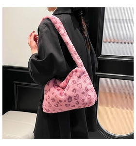 Detail of pink leopard print faux fur shoulder bag worn with a black winter coat