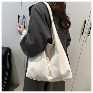 Detailed side view of white leather shoulder bag draped elegantly on model for daily use
