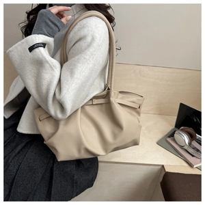 Grand sac fourre-tout beige en cuir porté à l'épaule pour l'usage quotidien
