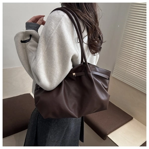 Gros plan d'un sac cabas marron foncé en cuir litchi avec plis et bandoulière
