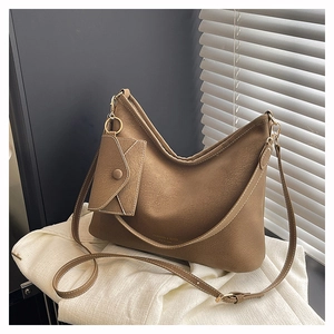 Close-up of brown suede tote bag with contrast stitching and matching mini pouch