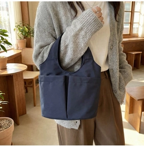 Detail of dark blue canvas bucket bag featuring dual large front pockets for storage