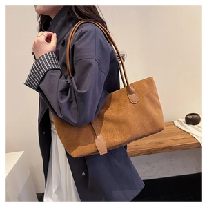 Caramel faux suede tote bag shown on model with shoulder straps for commute