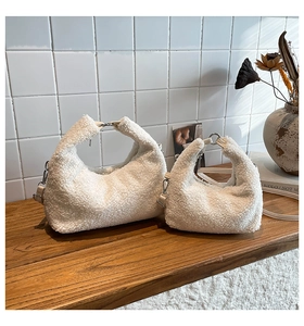 Ensemble de deux sacs bandoulière en polaire blanche teddy sur un banc en bois