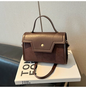 Detail of brown leather bag with gold buckle on Tom Ford fashion book