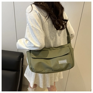 Army green nylon messenger bag shown on model for size perspective and drape
