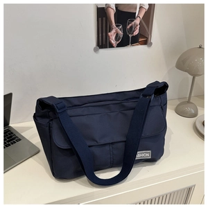Gros plan d'un sac messager en nylon bleu marine avec une étiquette FASHION grise
