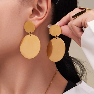 Boucles d'oreilles double disque dorées avec bague et collier assortis sur modèle