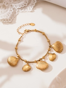 Macro detail of gold plated stainless steel shell charms on a box chain bracelet