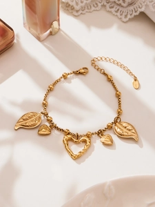 Detail of gold heart charms and leaf pendants on stainless steel beaded chain
