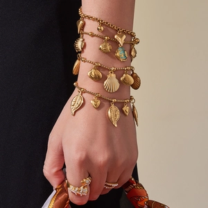 Gold layered ocean charm bracelet with shell pendants and panther head ring set