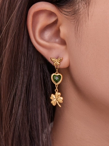 Detail of stainless steel butterfly earring with heart green stone and clover drop