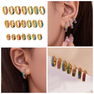 Detalle de tres tamaños de pendientes en U dorados con pavé de circonitas de colores
