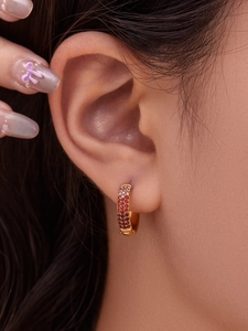 Detalle de pendientes en U chapados en oro de 18k con circonitas rosas y rojas pavé