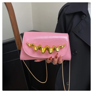 Détail du sac boîte en acrylique rose avec poignée ondulée dorée et fini brillant