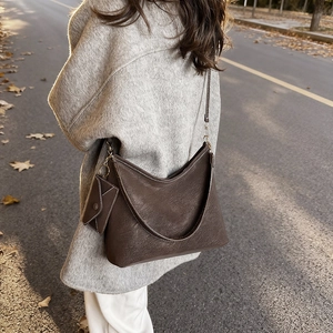 Retro deep brown large tote bag with mini envelope charm on a sunny autumn street