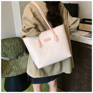 Detail of a large cream tote bag with pink trim and embossed cartoon patterns