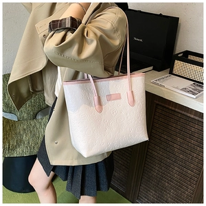Detail of white tote bag with embossed cartoon patterns and pink leather handle straps