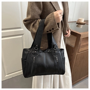 Close-up of black lychee texture tote bag with double zippers and metal hardware