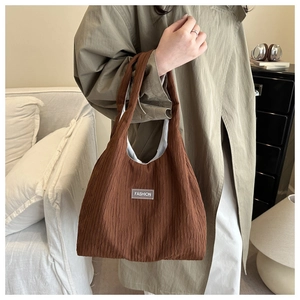 Brown pleated slouchy handbag with Fashion label for women in casual home setting