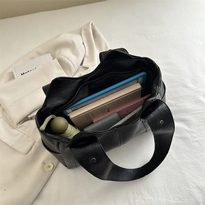 Black high-capacity tote bag in glossy leather with wide shoulder straps and large interior