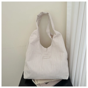 Detail view of cream pleated corduroy tote bag showing soft ribbed texture and fashion patch