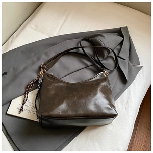 Détail du sac à bandoulière en similicuir marron foncé avec fermeture éclair dorée