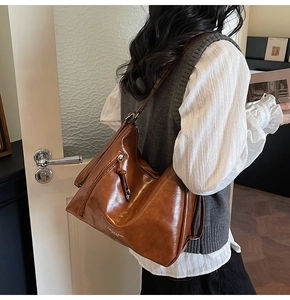 Detailed view of the matte brown PU leather tote bag featuring retro metal zipper accents