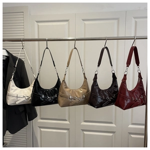 Five assorted half-moon hobo bags in cream, black, brown and wine red hanging on a rack