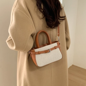 Retro canvas and leather handbag with orange-brown straps shown on model in wool coat