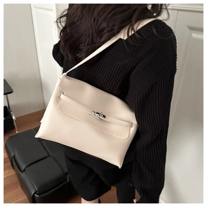 Dettaglio borsa a tracolla crema minimalista con decoro a cinturino e chiusura a girello