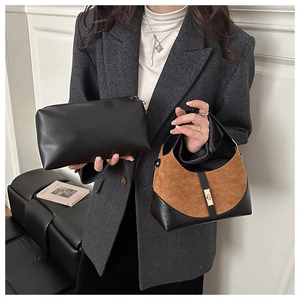 Detail of minimalist black leather bucket bag and brown suede hobo bag for women