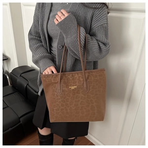 Detailed view of leopard print tote bag with gold lettering and slim shoulder straps