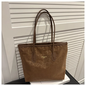 Close-up of brown leopard print tote bag with gold logo on white shutter background