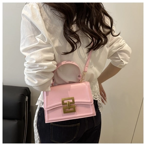 Pink matte leather crossbody bag with bronze H-buckle shown on a female model