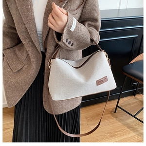 Close-up of vintage canvas and brown leather crossbody bag with gold metal hardware