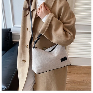 Beige knitted shoulder bag paired with camel wool coat on a person for daily look