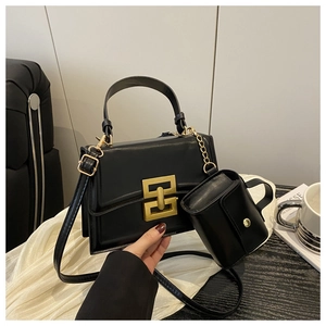 Close-up of black PU leather square bag with gold buckle and mini charm pouch