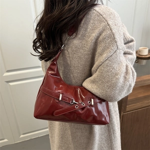 Deep red glossy patent leather shoulder bag with chic silver hardware details and eyelets