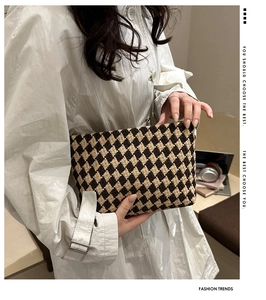 Detail of vintage houndstooth jacquard makeup bag held by model in professional setting