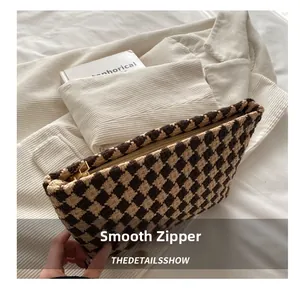 Detail showing a smooth gold zipper on a houndstooth pattern evening clutch bag