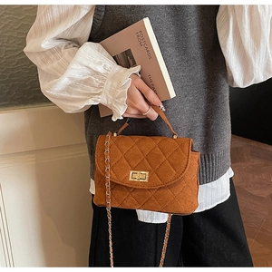 Detail of caramel quilted wool crossbody bag with golden twist lock and chain strap