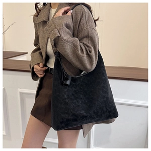 Detailed view of the black matte leather Hobo bag worn on the shoulder by a model