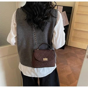 Detail of coffee brown quilted chain bag with gold twist lock and matte texture finish