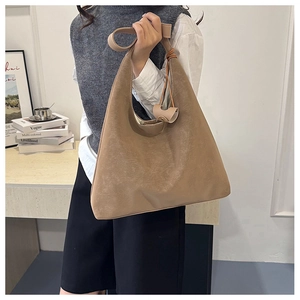Detail of khaki tote bag with textured faux leather and decorative side tassel