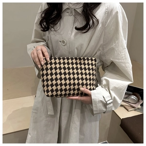 Detail of woven checkerboard clutch in brown and beige with vintage cotton texture