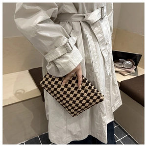 Detail of checkered knit handbag with vintage texture in a cozy social setting